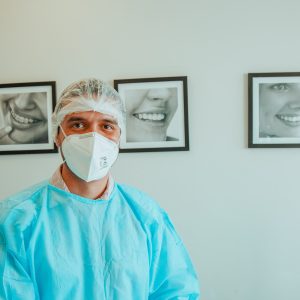 Male Professional Dentist With Gloves And Mask And Discuss What The Treatment Will Look Like Of The Patient's Teeth. Discussion Of The Treatment Plan And Healthy Smile