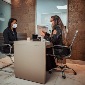 Male Professional Dentist With Gloves And Mask Holding papers photo And Show What The Treatment Will Look Like Of The Patient's Teeth. Discussion Of The Treatment Plan And Healthy Smile